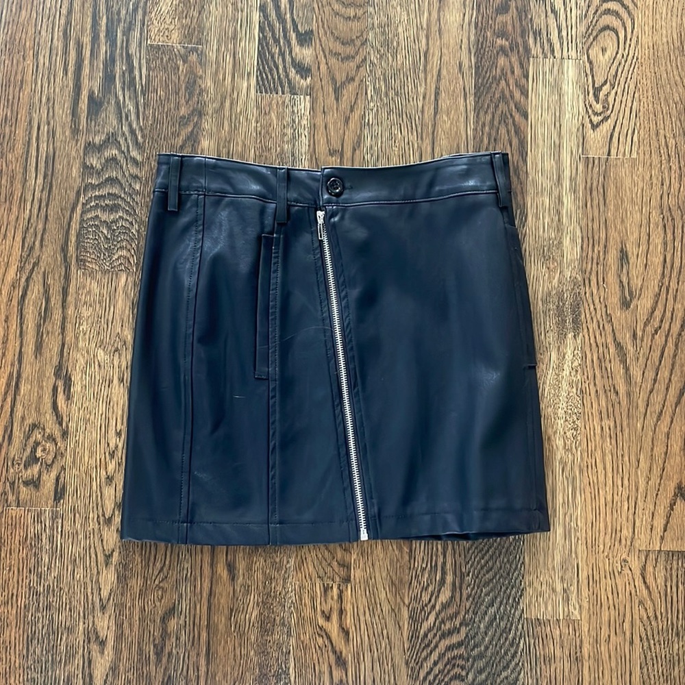 Black faux leather mini skirt with zipper detail, size Medium.